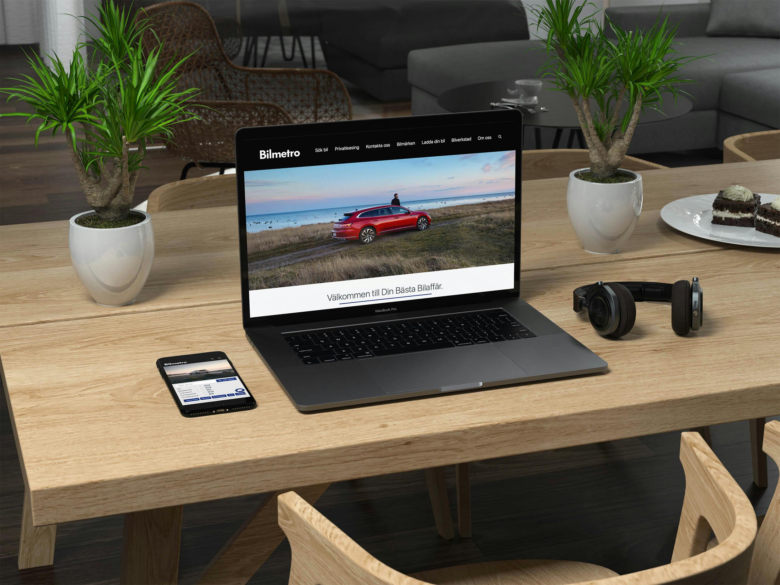 Bilmetros hemsida på dator/laptop och mobil på ett skrivbord