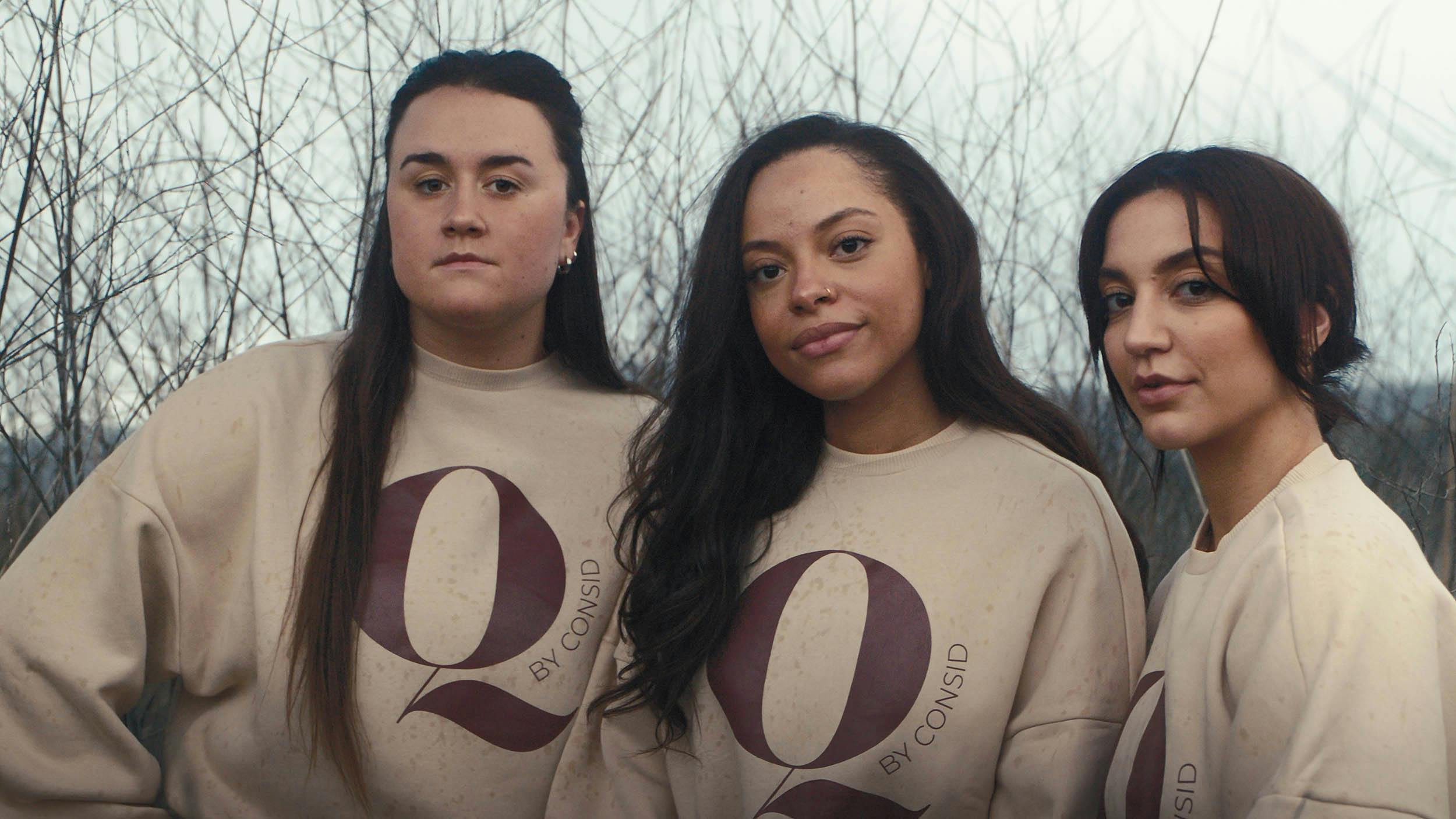 Tre kvinder har en Q by Consid sweatshirt på