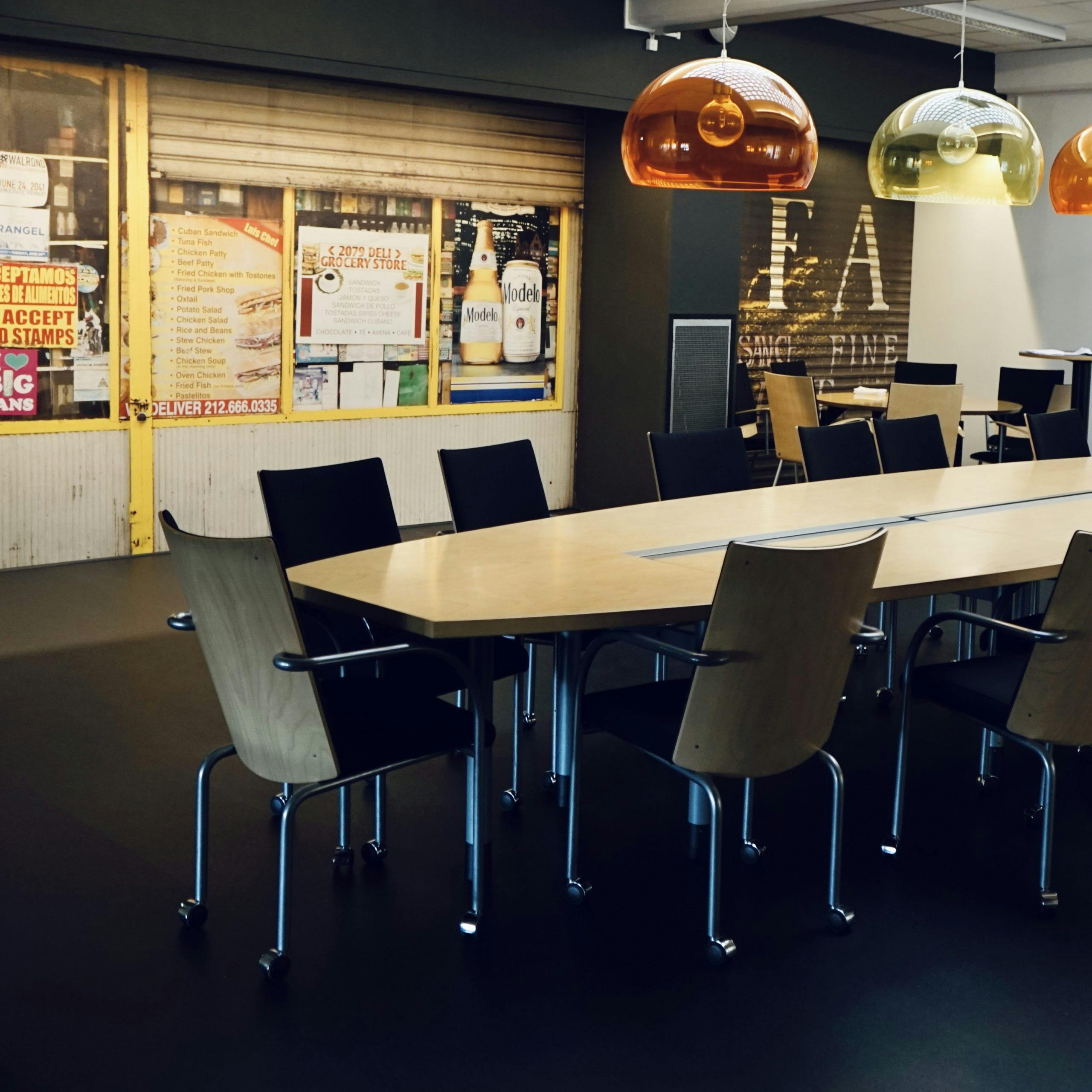 Mötesbord med tillhörande stolar och vägg med posters i bakgrunden på Consids kontor i Borås.