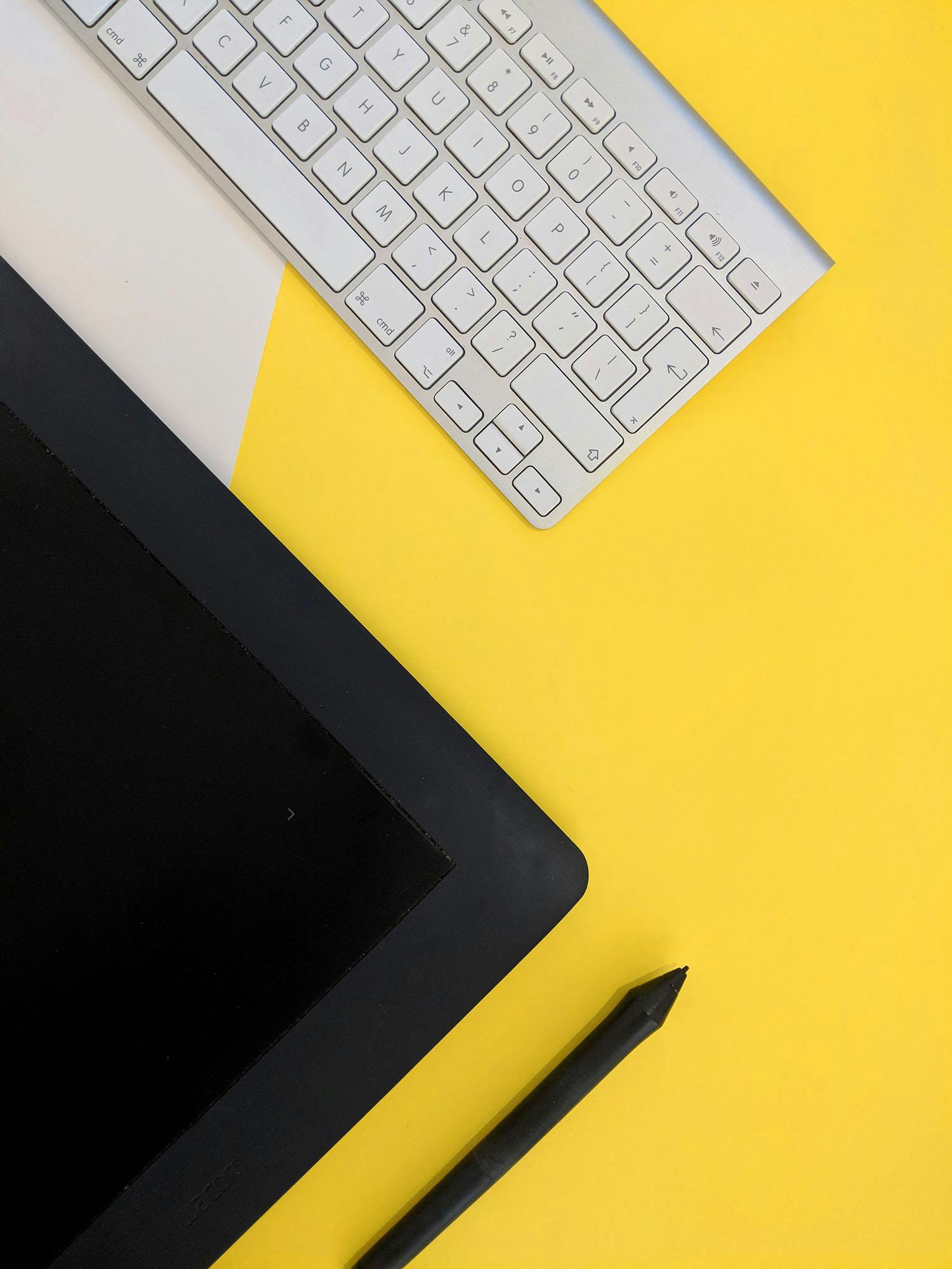 Tablet and keyboard on yellow desk