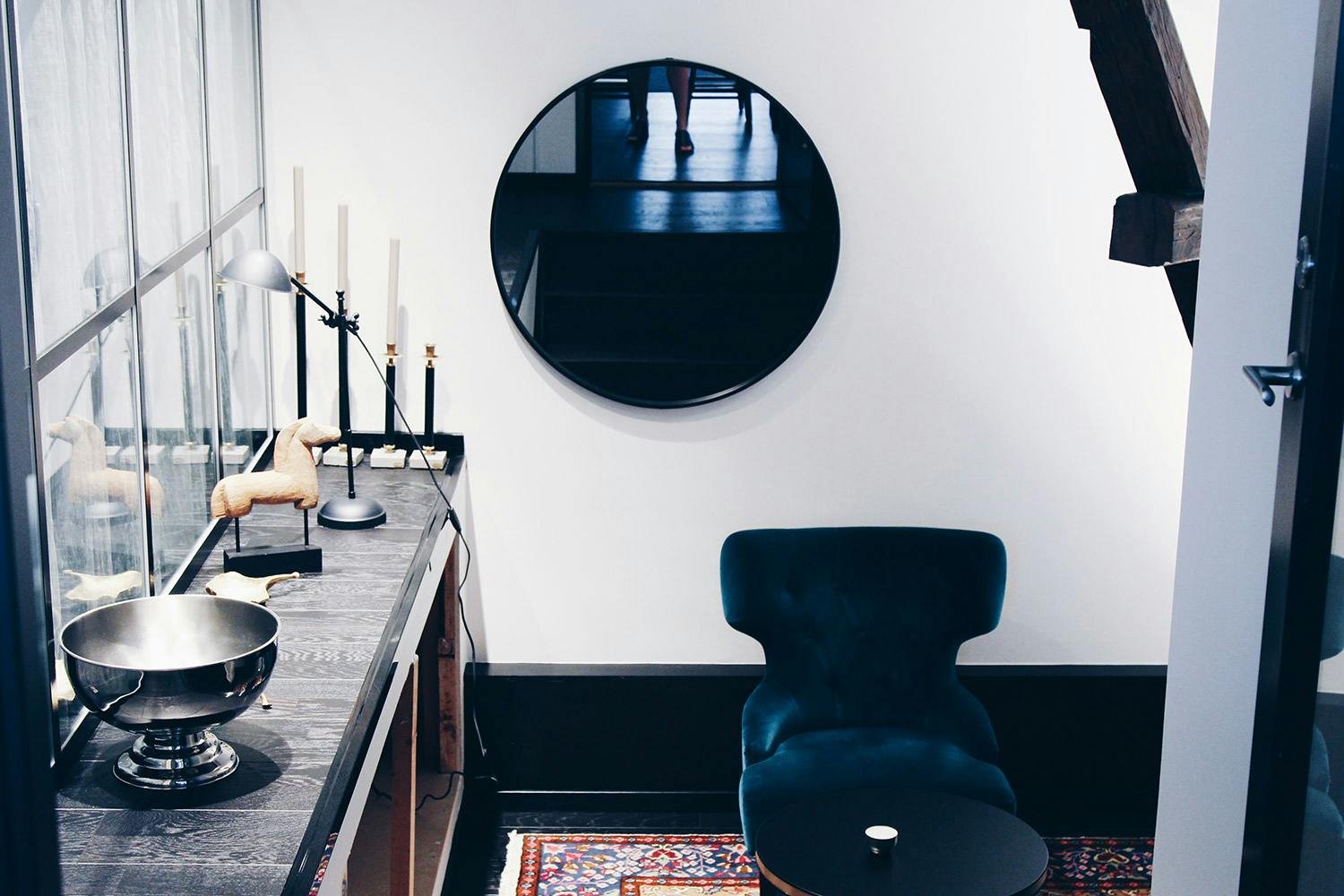 Fåtölj, rund spegel och hylla på Consids kontor i Helsingborg
