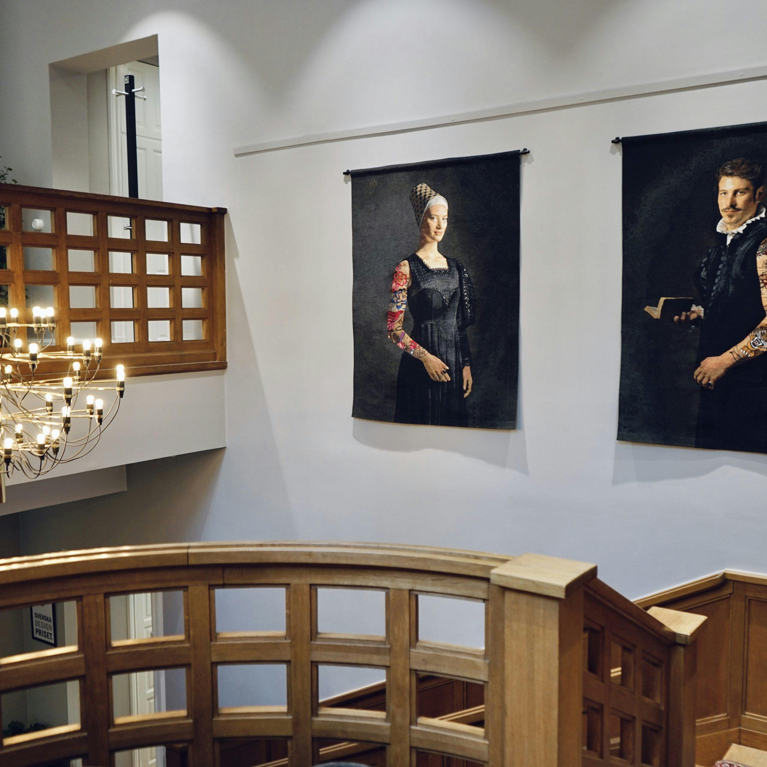 Paintings depicting a man and a woman on the wall in the stairwell at Consid's office in Linköping.