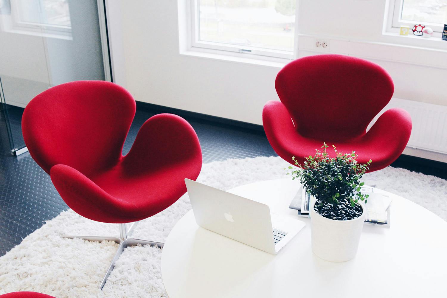 Red armchairs next to a white table at Consid's office in Ljungby