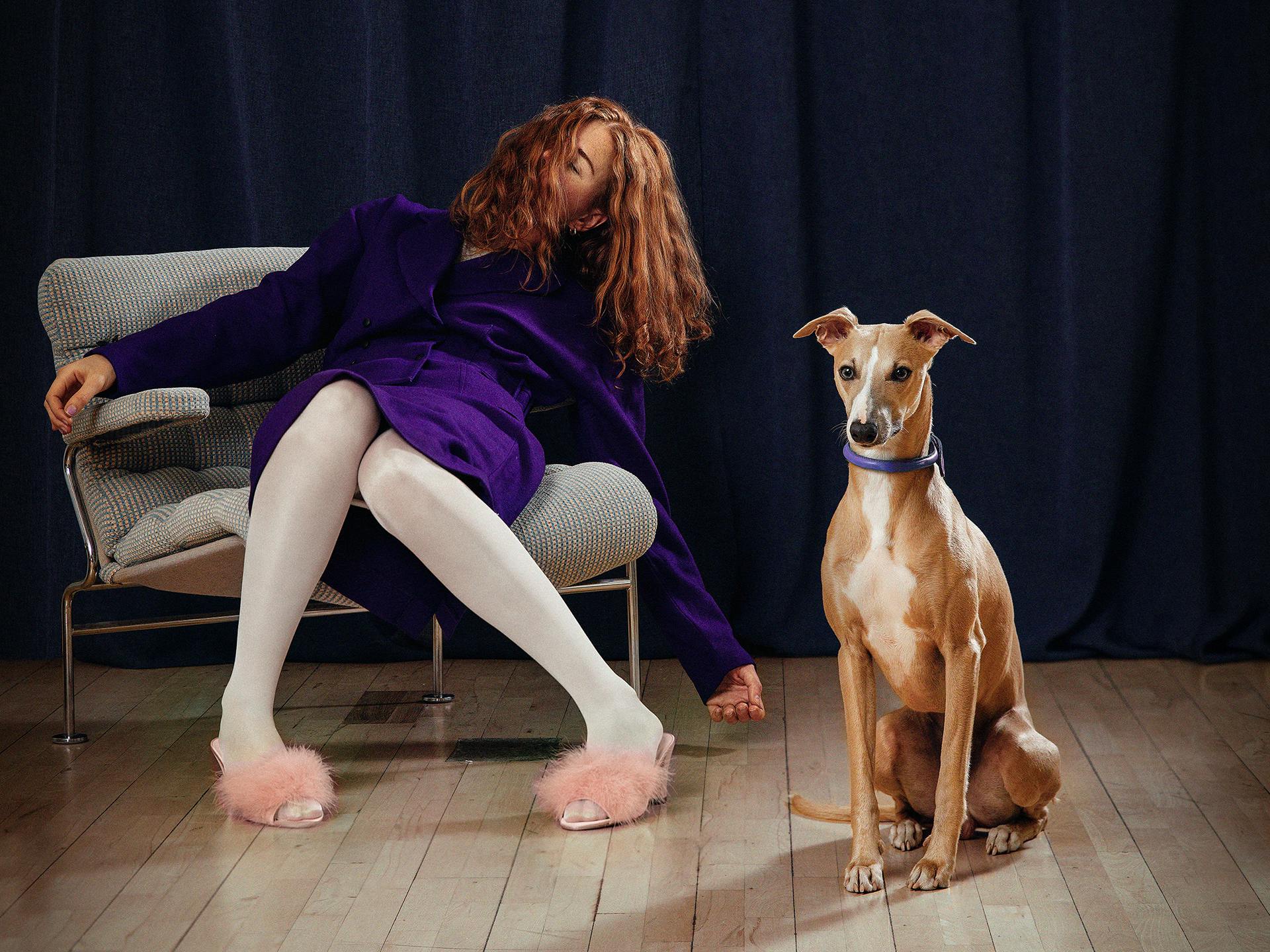 En kvinna som sitter i en fåtölj och en hund