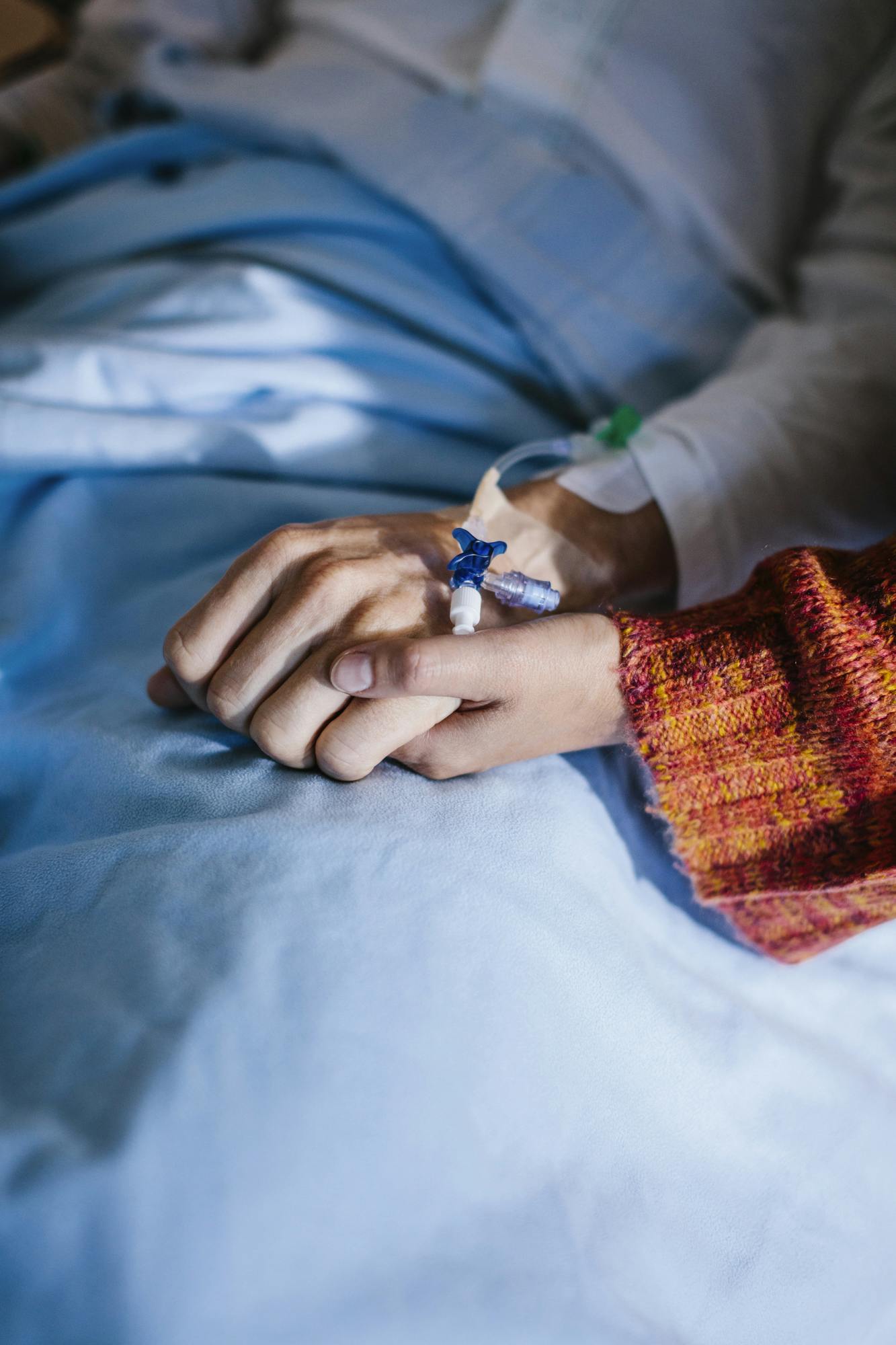 Två personer håller varandra i handen på sjukhus, Care of Sweden