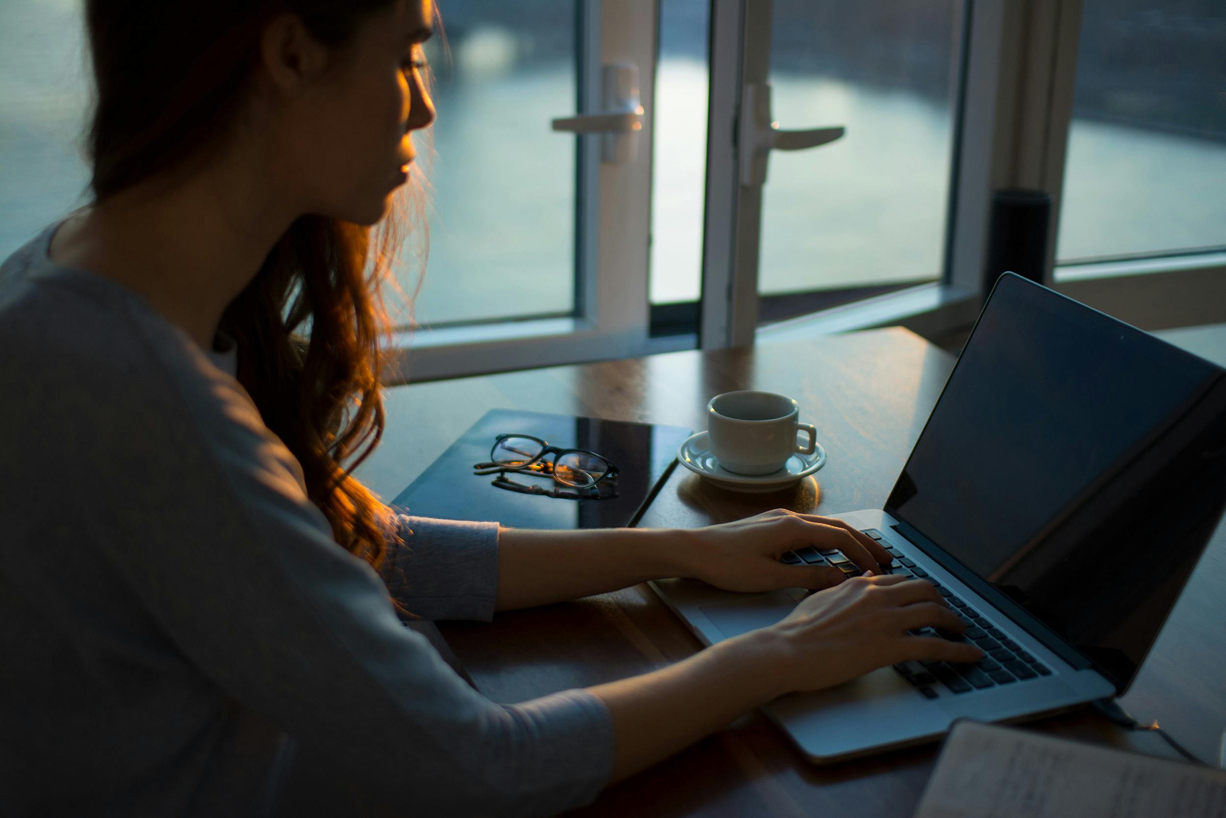 Kvinna jobbar hemifrån på distans vid sin dator