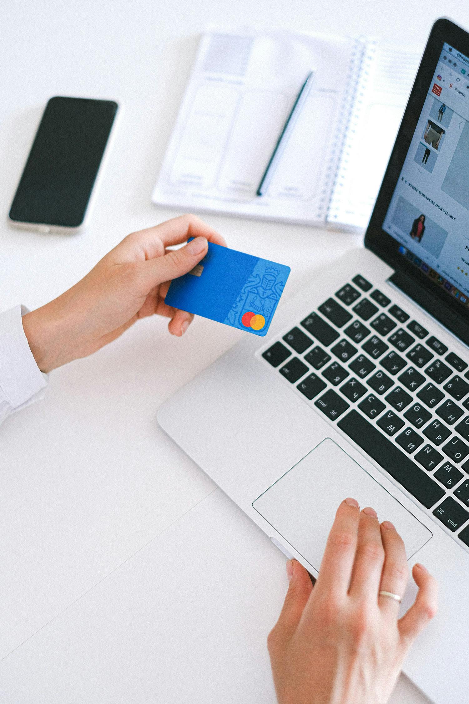 Att e-handla på nätet med sitt kreditkort framför en laptop