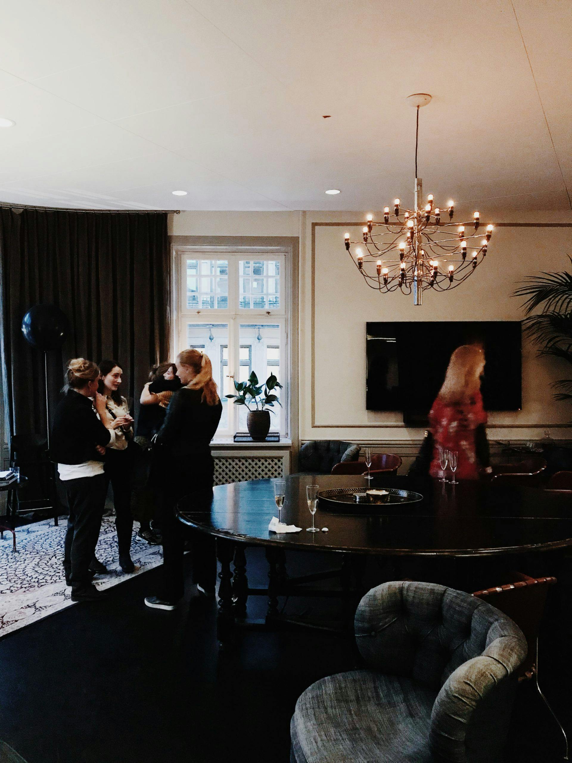 Kvinnor står och som samtalar bredvid runt bord på Consids kontor i Stockholm.