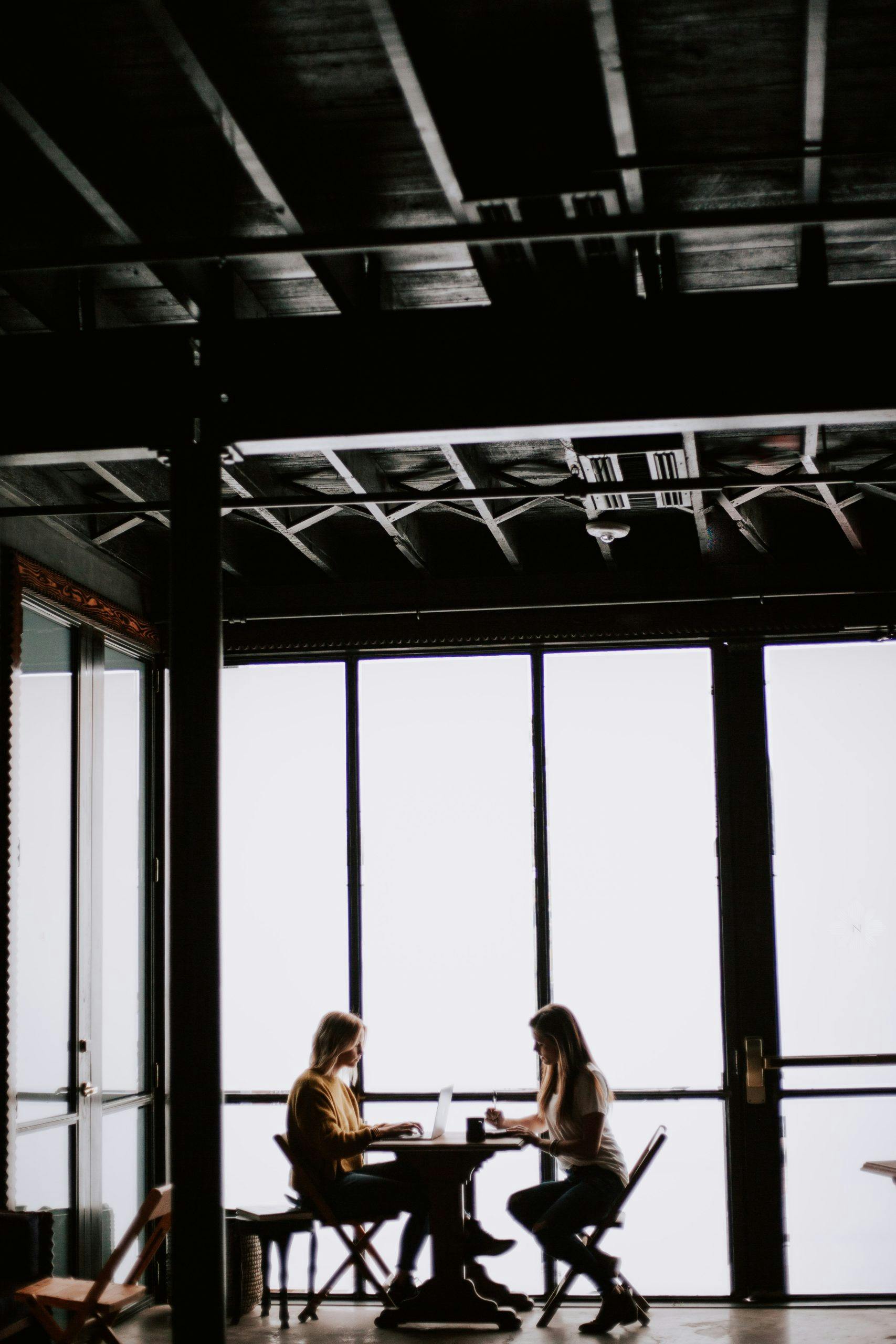 Modern Workplace två kvinnor sitter och arbetar vid ett fönster