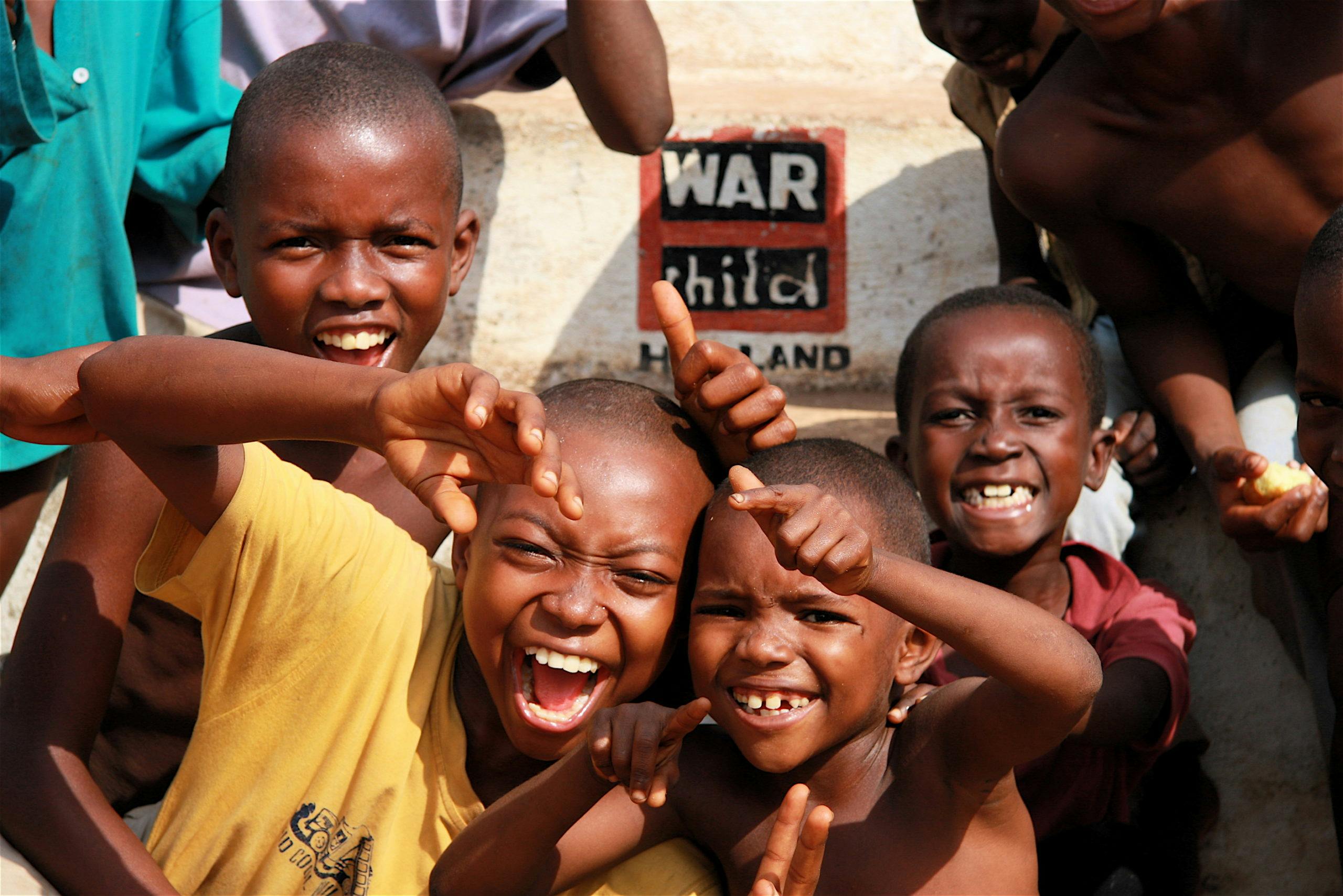 Children laughing in front of text war child.