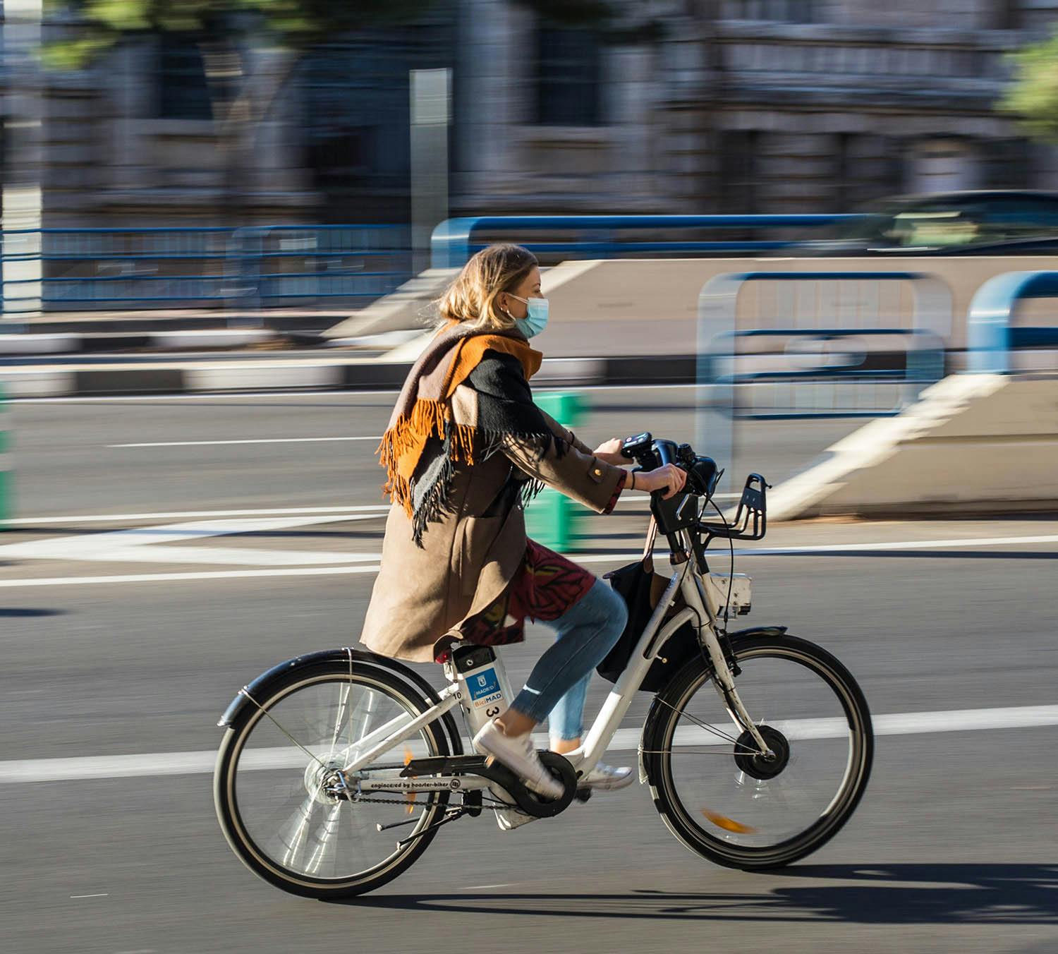 En kvinna som cyklar i stadskärna
