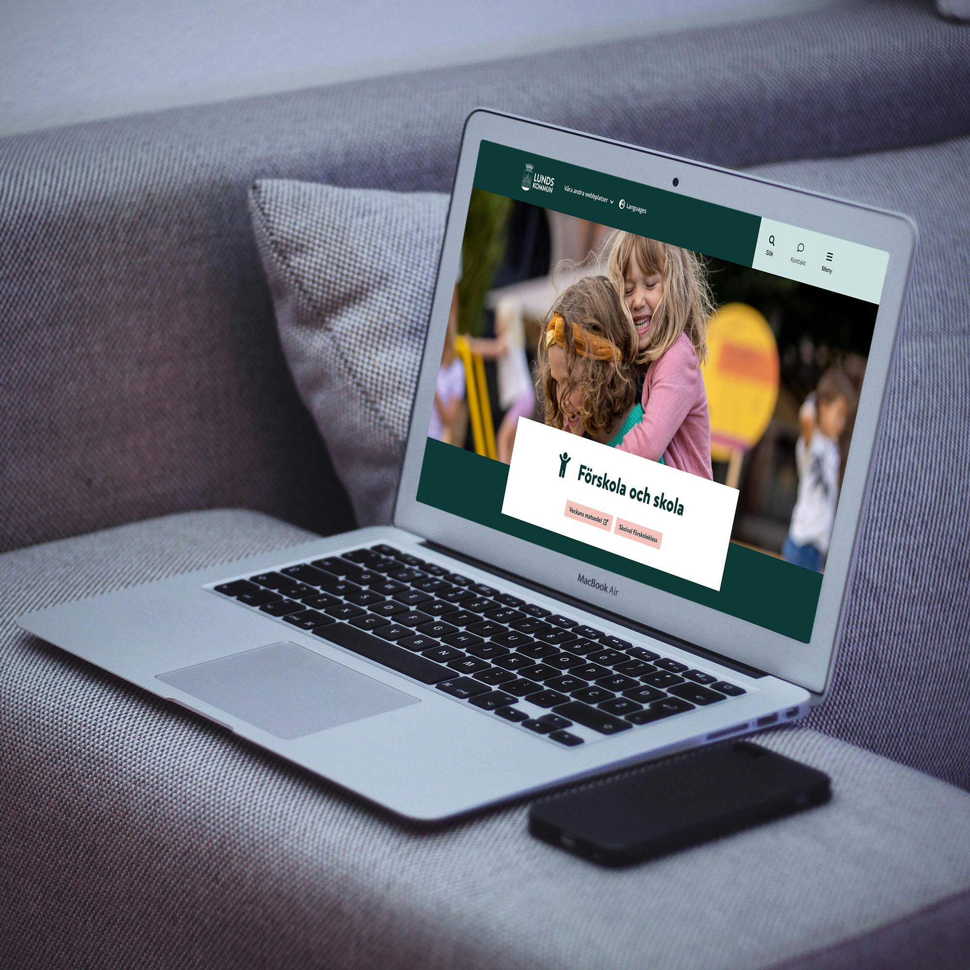 Lund kommuns nya webbplats utvecklad av Consid, i en MacBook Air på armstödet av en grå soffa